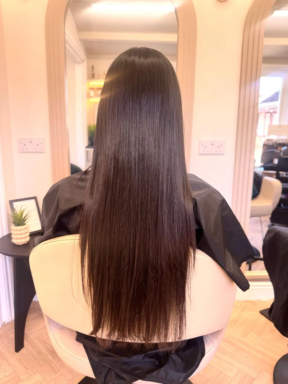 Long, sleek, glossy dark-brown hair after a smoothing treatment